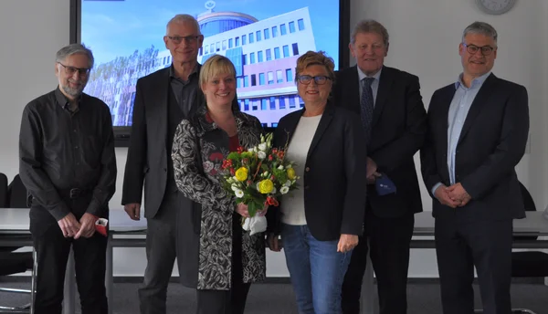 Frau Weise mit Blumenstrauß mit Vorstand und Vorsitzenden der Vertreterversammlung sowie Geschäftsführer Michael Laßok
