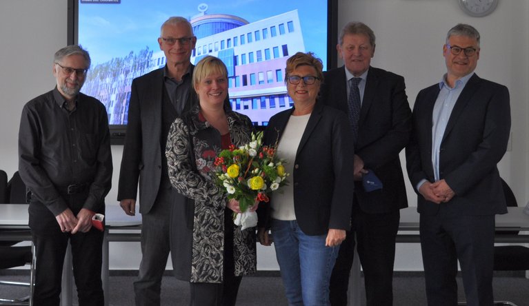 Frau Weise mit Blumenstrauß mit Vorstand und Vorsitzenden der Vertreterversammlung sowie Geschäftsführer Michael Laßok